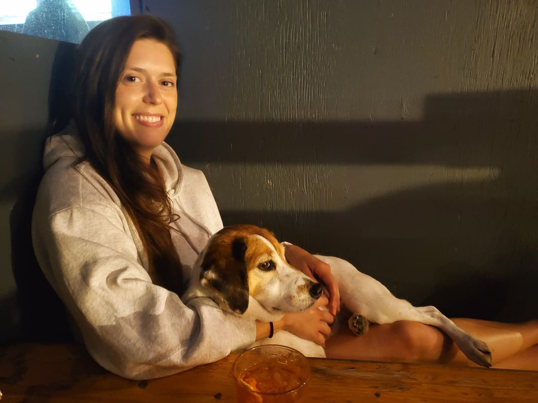 woman and dog sitting on patio at restaurant